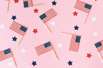 Many little american flags and stars on pink background, flat lay. 4th of july, happy usa...