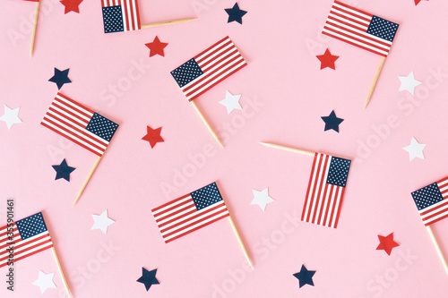 Many little american flags and stars on pink background, flat lay. 4th of july, happy usa independence day. Celebration in America, good mood.