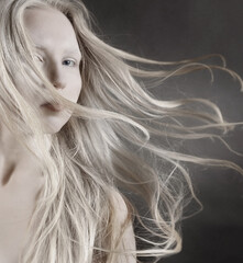 Conceptual art portrait of a young blonde girl with her hair flying