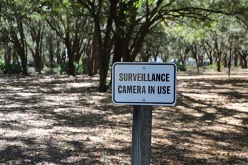 Surveillance camera warning sign in public park