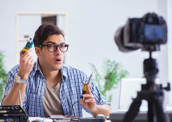 Vlogger recording computer repair on camera for vlog blog