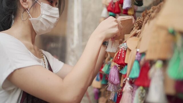 Asian young woman wear white medical mask praying wishing at temple, wish for the better life, believe in spirit tradition, covid-19 virus pandemic, new normal life,natural day light, close up shot