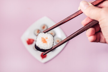 Female Hand Holding Sushi Japanese Food Sushi with Salmon Top View Horizontal