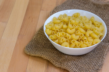 Close up of Macaroni in a white bowl placed on the table, selective focus - 355905021