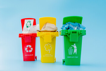 Yellow, green and red recycle bins with recycle symbol on blue background. Keep city tidy, Leaves the recycling symbol. Nature protection concept