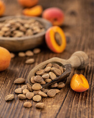 Vintage wooden table with shelled Apricot Kernels (selective focus)