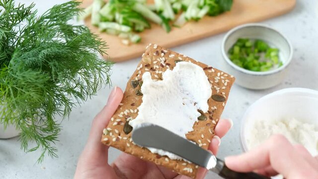 Spreading cream cheese on rye cracker crispbread. Healthy snack