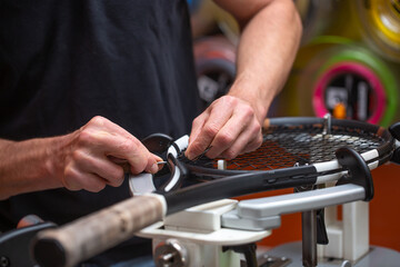 Process of stringing a tennis racket in a tennis shop, sport and leisure concept