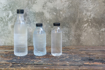 plastic water bottles on the old wooden table background. - 355907806