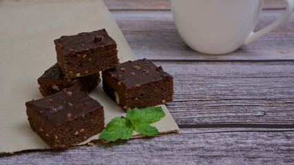 Chocolate brownies nuts squares on wooden table.