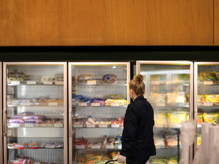 supermarket shopping, face mask and gloves,Woman choosing frozen food from a supermarket freezer