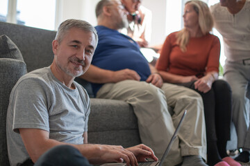 Obraz premium man using a laptop sitting on the floor in the living room.