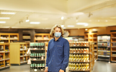 Supermarket shopping, face mask and gloves,Young man shopping in supermarket, reading product information