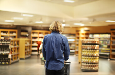 Supermarket shopping, face mask and gloves,Young man shopping in supermarket, reading product information