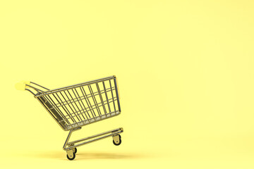 Empty shopping cart with yellow background, 3d rendering.