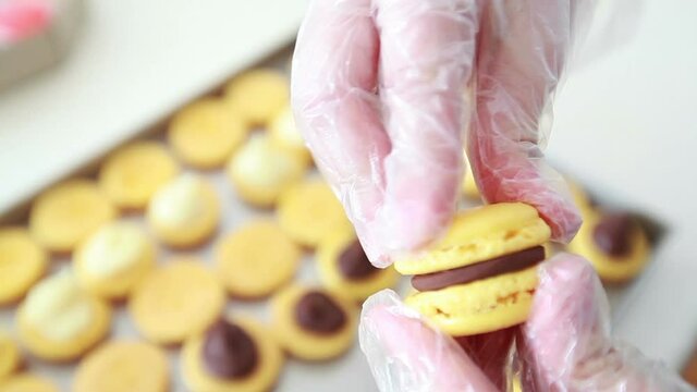 delicious french cake making macarons shells with chocolate cream, small business concept