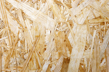 Construction materials made of chipboard. OSB wood panel made of pressed sand brown wood shavings...