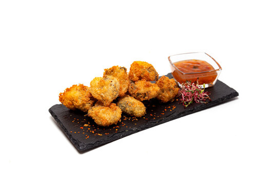 Fried rapans with sauce on a white background