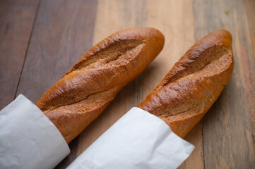 Two baguettes on the wooden background, Bread that is long and hard