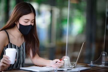 Asian business woman working from home, concept of social distancing and new normal lifestyle,...