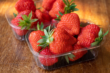 Fresh ripe sweet pink lambada strawberry in plastic boxes ready to eat