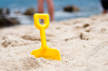 Toy plastic shovel on the sand