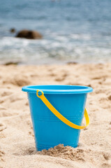 Blue toy plastic bucket on the beach
