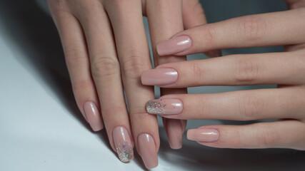 Manicure on female hands with nude nail polish. Beautiful nude nails. Hand with beautiful nude...