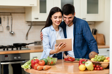 Lovely couple preparing salad together at home