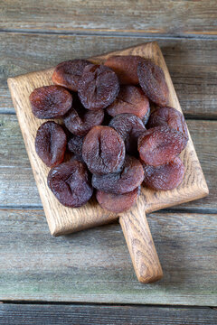 Dried dark apricots on rustic wooden background, chocolate tipe. 