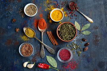 Background with colorful spices. Herbs and spices selection - old metal spoons and ceramic cups. The concept of cooking, food or health.