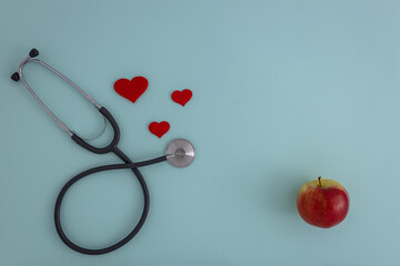 Red heart with stethoscope and Apple on a blue background