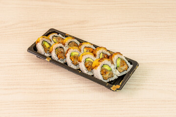 Ration of uramaki on wooden table