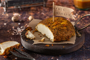 Home smoked rustic cheese on old kitchen board.