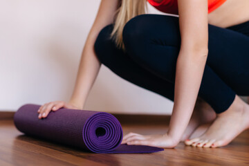 Cropped photo of sporty girl in fitness wear holding her yoga ma