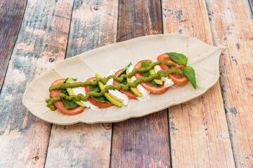 Plate of caprese salad on wooden table