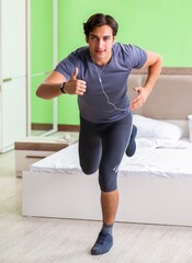 Young handsome man doing morning exercises in the hotel room