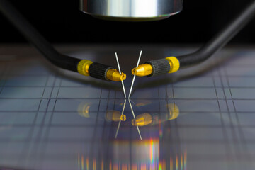Manual probe system with needles for test of semiconductor on silicon wafer. Selective focus.