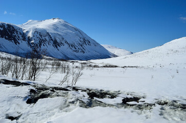 warm sunshine on snowy mountain in springtime in northern Norway
