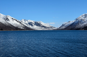 beautiful snowy mountain and deep blue fjord in spring time in northern norway