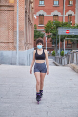 Latin girl skating on inline skates protecting herself with a face mask