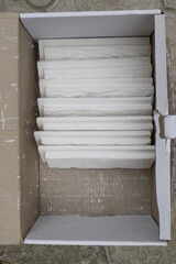 White gypsum brick for interior use in a cardboard box, top view.