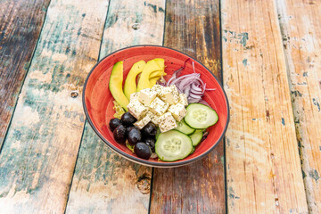 bowl of greek salad on wooden table