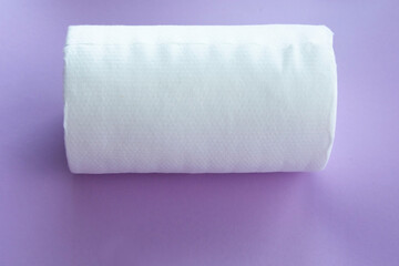 Roll of white disposable nonwoven fabric napkins isolated on pink