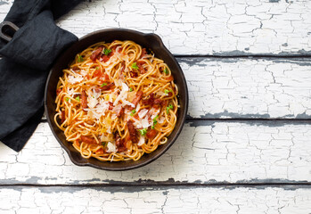 Italian pasta with roasted sausages, tomato sauce and parmesan cheese in a skillet