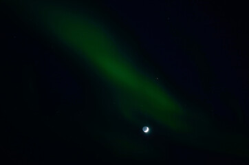 aurora borealis and full moon in winter night in the deep arctic circle