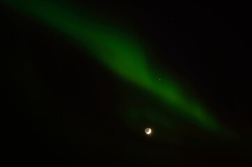 aurora borealis and full moon in winter night in the deep arctic circle