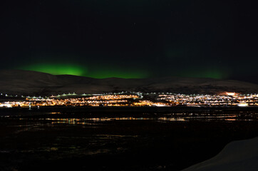 mighty northern light dancing over snowy mountain peak in northern norway on the whale island settlement