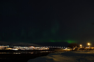 aurora borealis dancing over whale island mountain and bridge in cold winter night