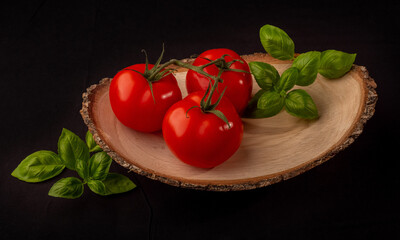 Frische Tomaten und Basilikum in Holzschale